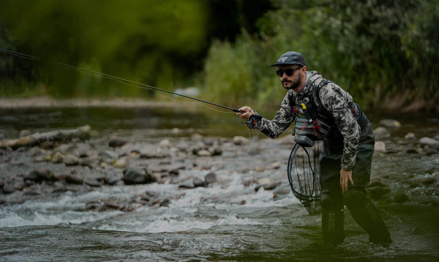 Fly fishing guide casting a line on an alpine river in the Dolomites